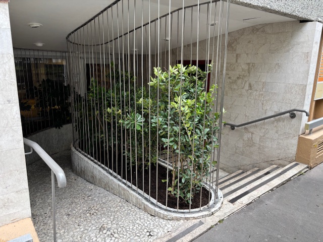 Hall d’immeuble végétalisé à Paris 15e avec bacs protégés par barreaudages métalliques