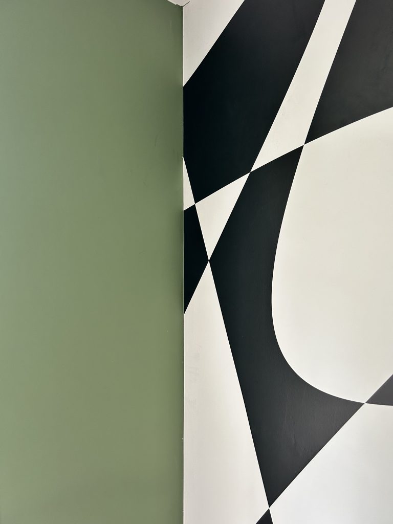 Papier peint graphique noir et blanc associé à un mur vert cactus – style Art Déco revisité