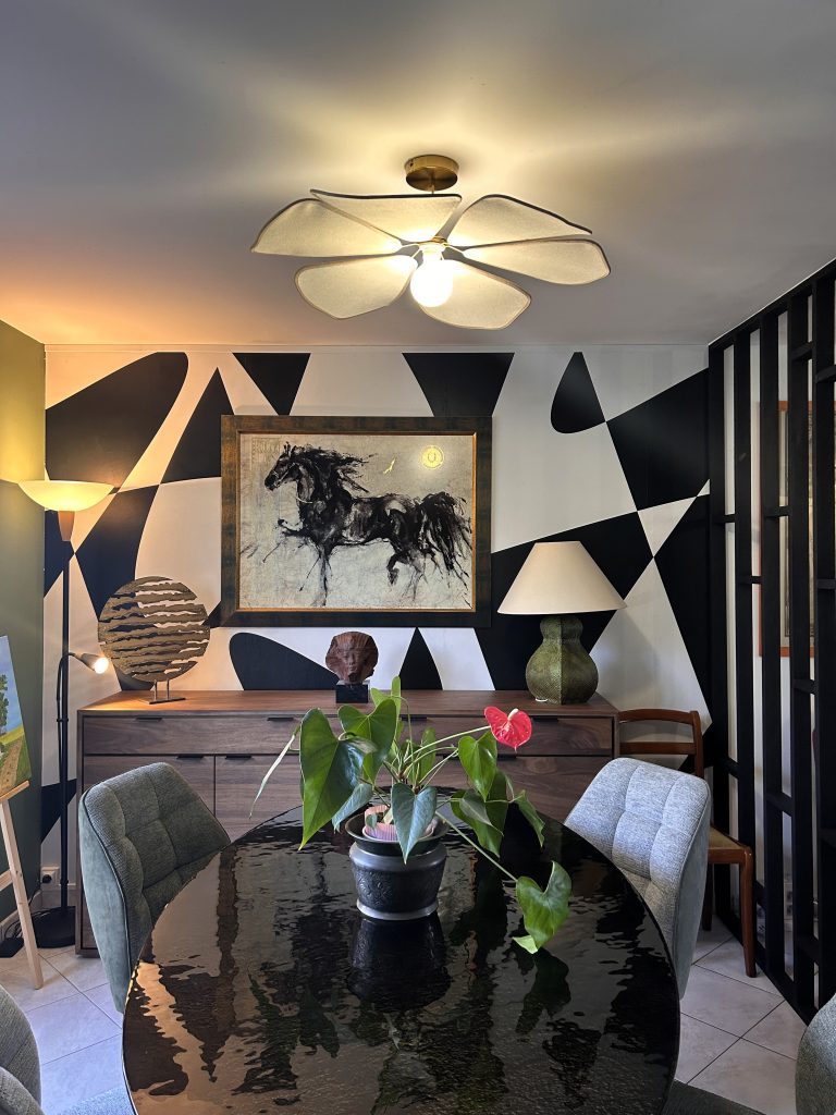 Salon rénové avec table ronde en bois, fauteuils gris et grande bibliothèque vert olive sur-mesure, signé Lunello.