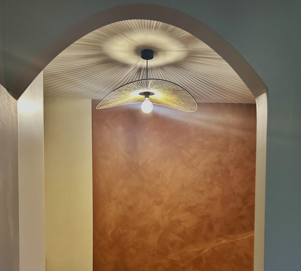 Mur-terracotta-illumine-par-une-suspension-ajouree-creant-une-lumiere-douce-et-chaleureuse-1-scaled.jpeg